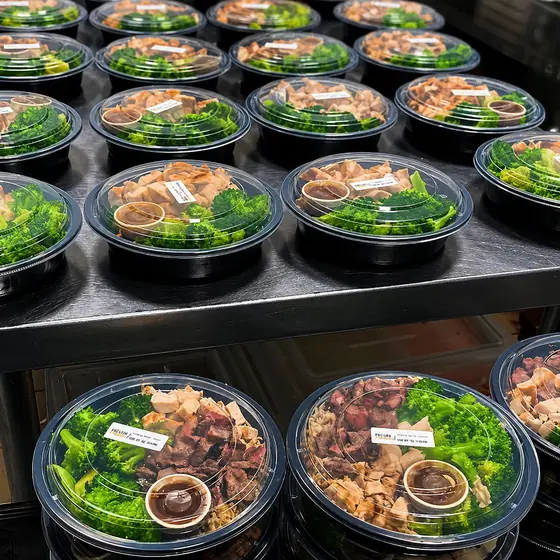 Rows of sealed Fresh Fork Grill bowls with chicken, steak, broccoli and Fork'n Sauce